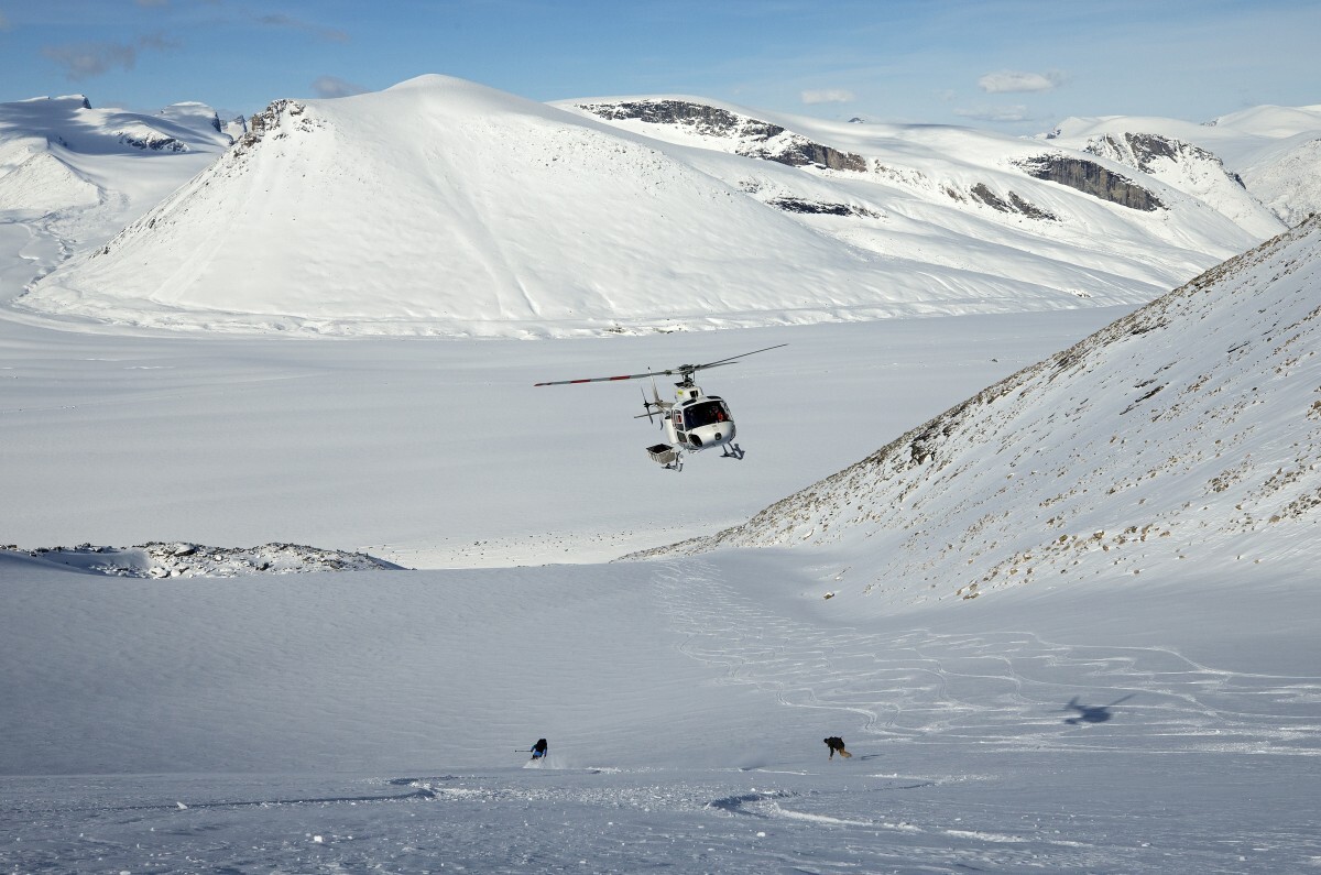 Skiers-and-helicopter-on-slope
